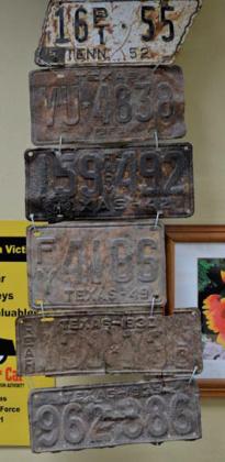 At top is a 1952 Tennessee license plate in the shape of the Volunteer State. Underneath hang Texas plates from 1963, 1942, 1949, 1930 and 1933. erick mitchell | Lampasas Dispatch Record